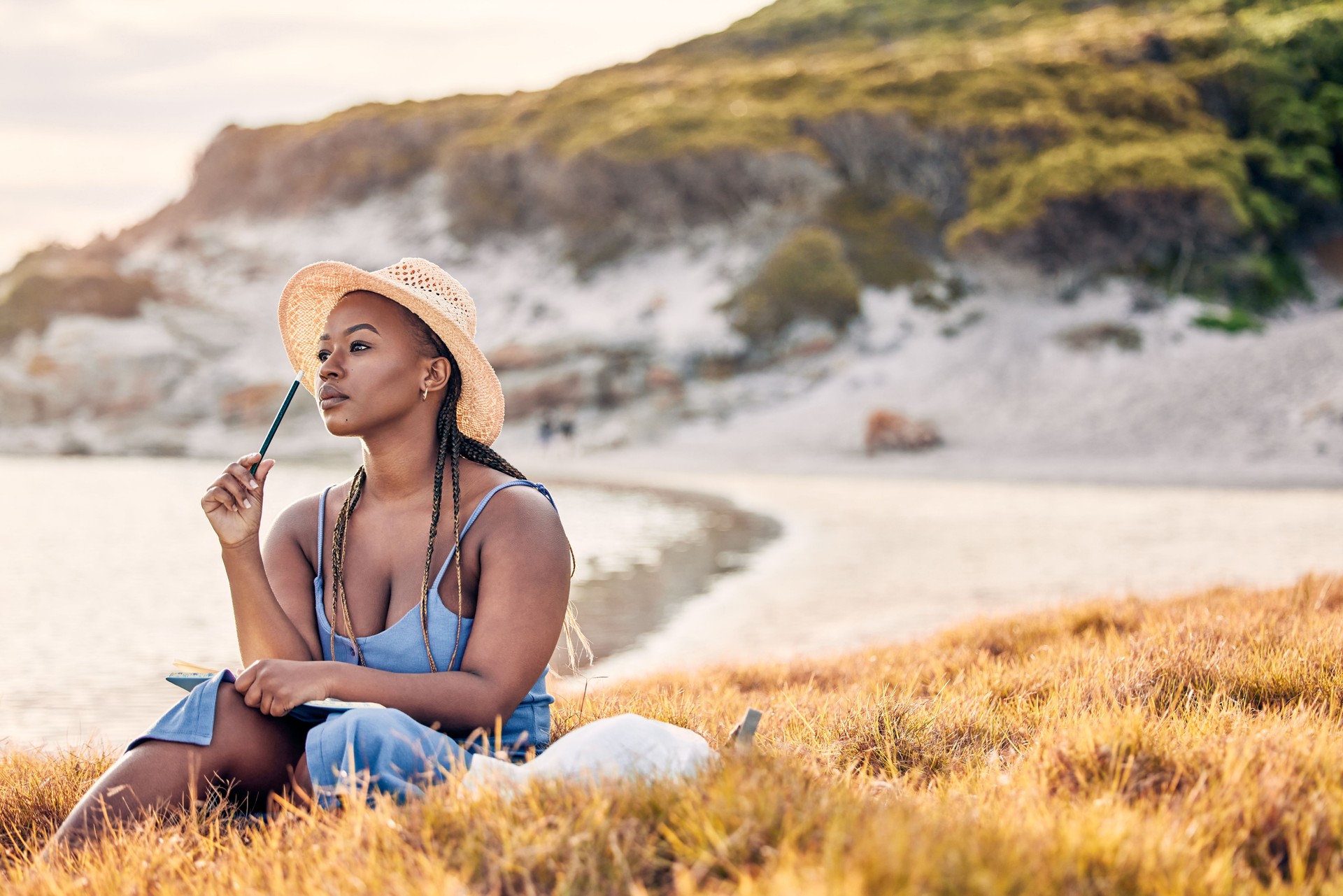 Shot of a young woman writing in her journal at the beach Shot of a young woman writing in her journal at the beach